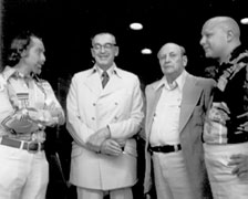 Black and white photo of Robert Silverberg, A.E. VanVogt, Horace L. Gold and E.J. Gold standing in conversation